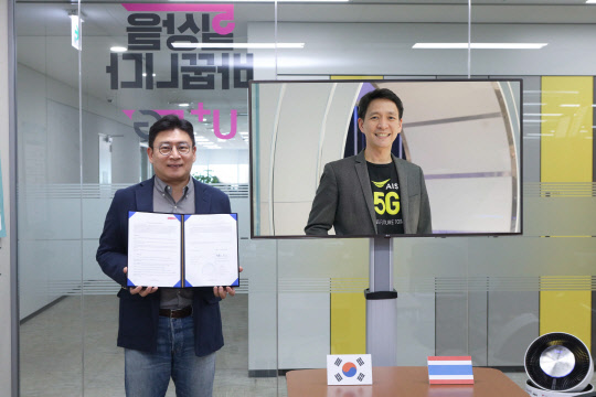 최윤호(왼쪽) LG유플러스 XR서비스사업담당(상무)가 태국 AIS 프라따나 릴라파낭 소비자사업최고책임자와 화상회의를 통해 5G 수출계약을 체결하고 있다. LG유플러스 제공